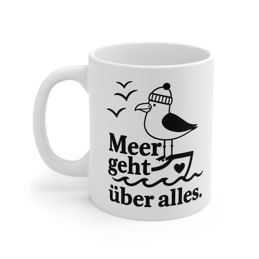 Weiße Keramiktasse mit Möwe auf einem Boot, Wellenmotiv und Spruch „Meer geht über alles“