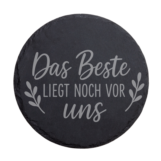 Runder schwarzer Schiefer-Untersetzer mit Gravur „Das Beste liegt noch vor uns“ und Blätterdesign