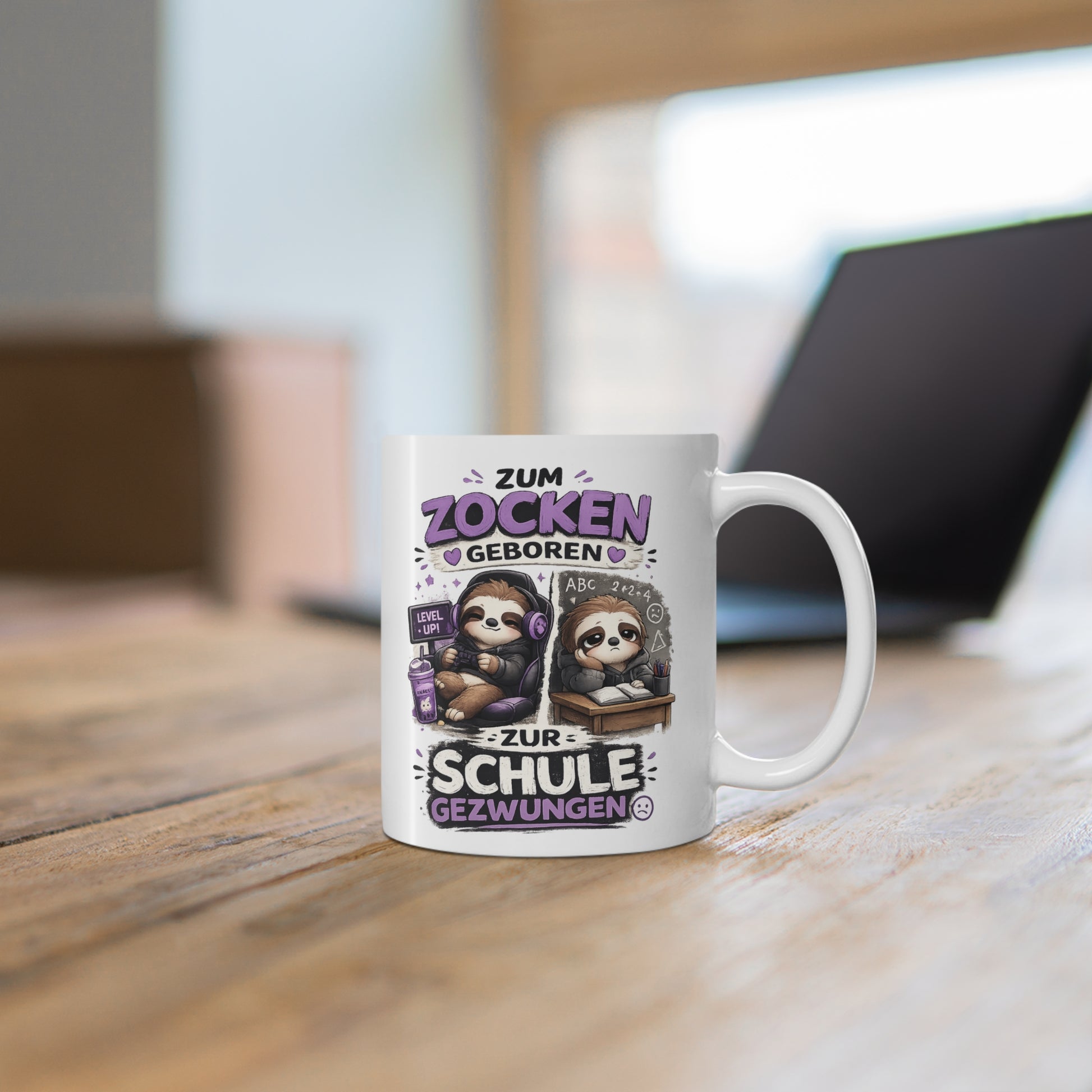 Weiße Tasse mit Faultier Gaming Motiv, Controller, Headset und humorvollem Schul Spruch auf einem Holztisch