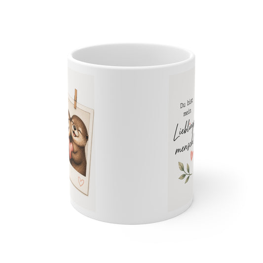 Rundum bedruckte Keramiktasse mit seitlich sichtbarem Ottermotiv und Liebesspruch auf weißem Hintergrund