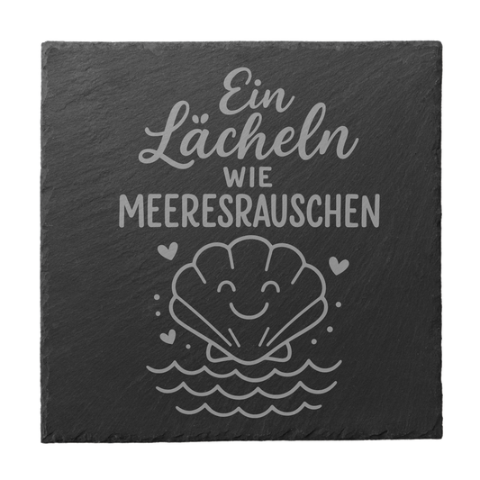 Quadratischer schwarzer Schiefer-Untersetzer mit Gravur „Ein Lächeln wie Meeresrauschen“ und lächelnder Muschel