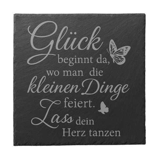 Quadratischer schwarzer Schiefer-Untersetzer mit Gravur „Glück beginnt da, wo man die kleinen Dinge feiert“ und Schmetterlingsmotiv