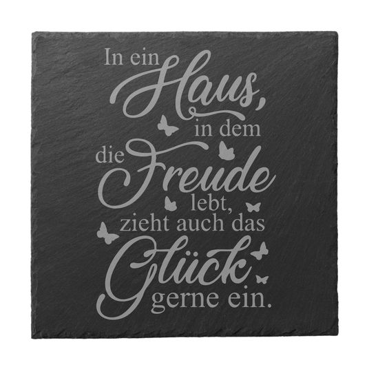 Quadratischer schwarzer Schiefer-Untersetzer mit Gravur „In ein Haus, in dem die Freude lebt, zieht auch das Glück gerne ein“