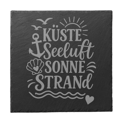Quadratischer schwarzer Schiefer-Untersetzer mit Gravur „Küste Seeluft Sonne Strand“, Anker, Muschel und Wellenmotiv