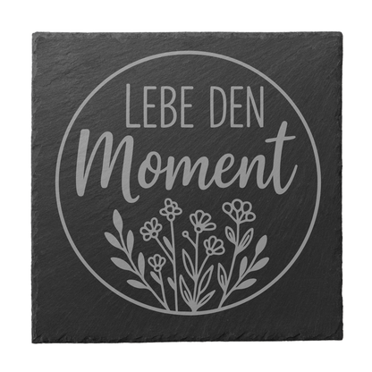 Quadratischer schwarzer Schiefer-Untersetzer mit Gravur „Lebe den Moment“ im Kreisdesign mit floraler Illustration