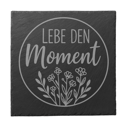 Quadratischer schwarzer Schiefer-Untersetzer mit Gravur „Lebe den Moment“ im Kreisdesign mit floraler Illustration