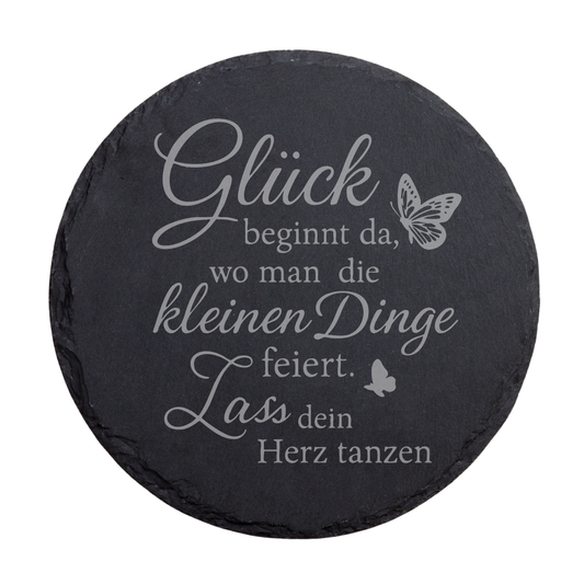 Runder schwarzer Schiefer-Untersetzer mit Achtsamkeitsspruch „Glück beginnt da…“ und dekorativem Schmetterling