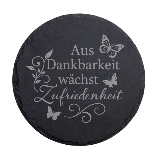Runder schwarzer Schiefer-Untersetzer mit Gravur „Aus Dankbarkeit wächst Zufriedenheit“ mit floralen Elementen und Schmetterlingen