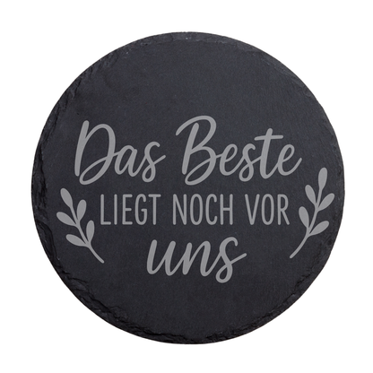 Runder schwarzer Schiefer-Untersetzer mit Gravur „Das Beste liegt noch vor uns“ und Blätterdesign