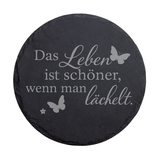Runder schwarzer Schiefer-Untersetzer mit Gravur „Das Leben ist schöner, wenn man lächelt“ und Schmetterlingen