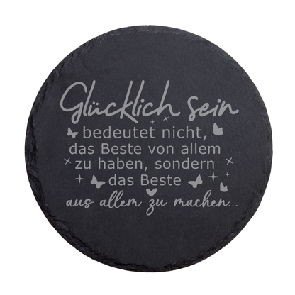 Runder schwarzer Schiefer-Untersetzer mit Spruch „Glücklich sein bedeutet nicht…“ und dekorativen Stern- und Schmetterlingsmotiven
