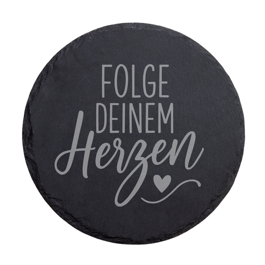 Runder schwarzer Schiefer-Untersetzer mit dem Spruch „Folge deinem Herzen“ in moderner Schrift