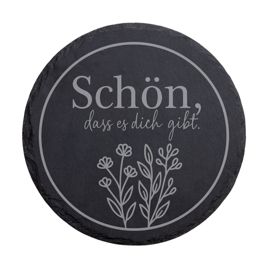 Runder schwarzer Schiefer-Untersetzer mit dem Spruch „Schön, dass es dich gibt“ im Kreisdesign mit floraler Illustration