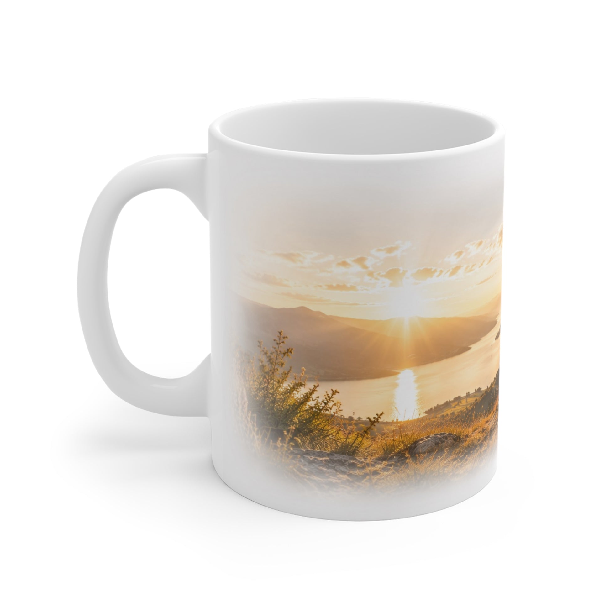 Weiße Tasse mit goldenem Sonnenuntergang über See und Bergen in warmer Naturkulisse