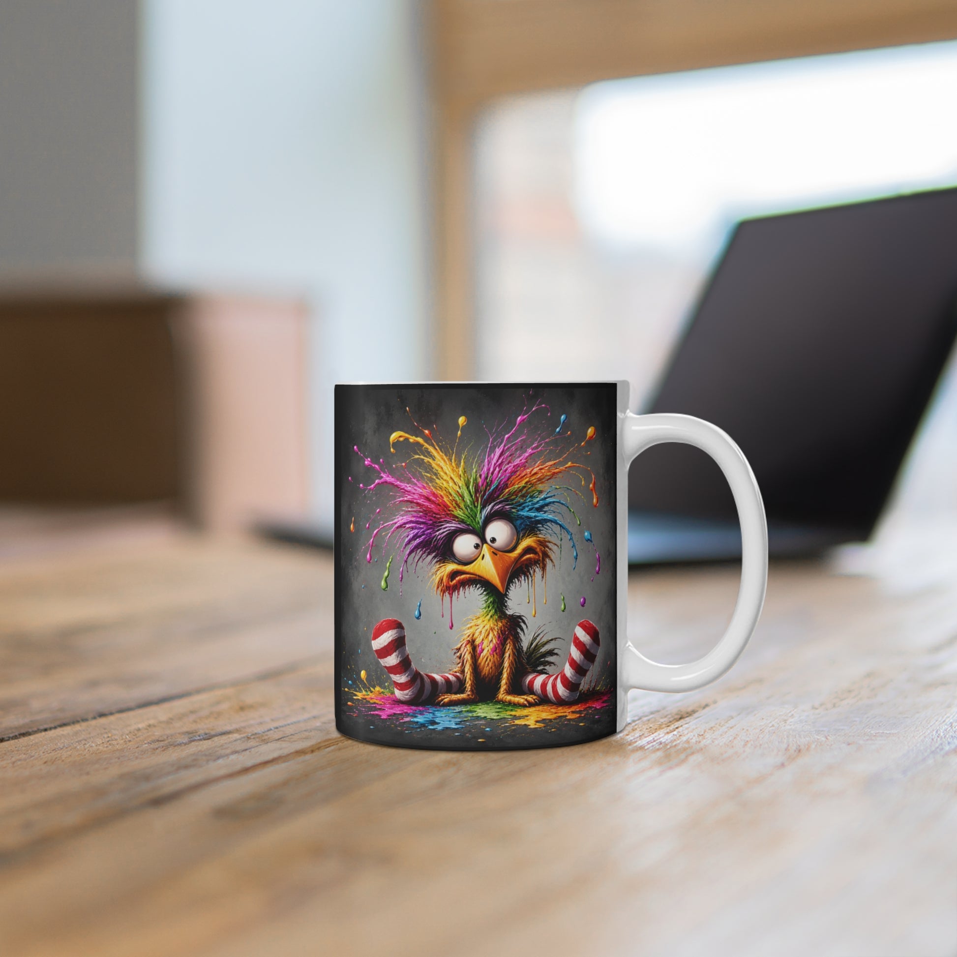 Weiße Tasse mit farbenfrohem Vogelmotiv auf Holztisch vor verschwommenem Hintergrund